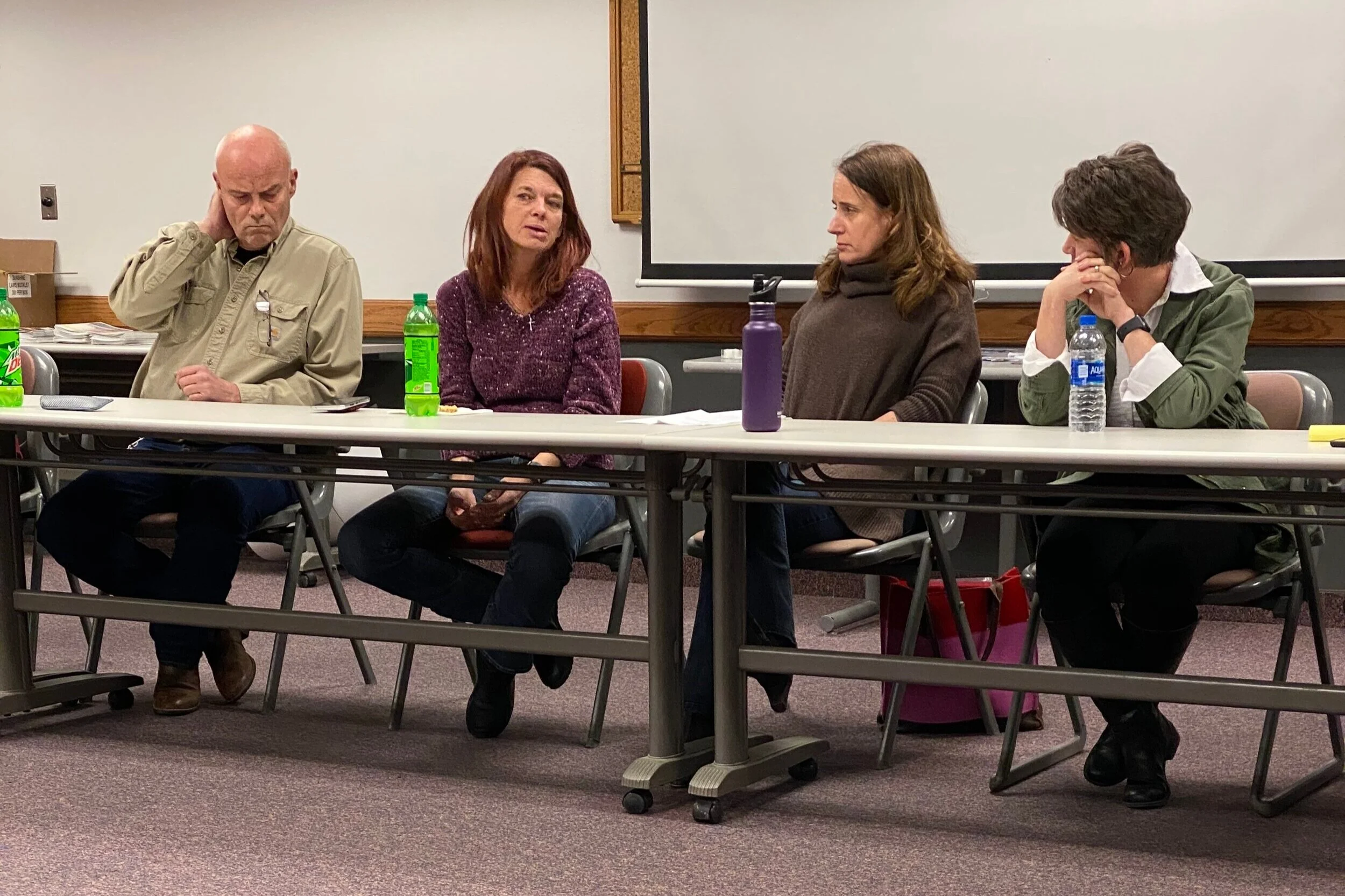 4 community members gather in at a long table